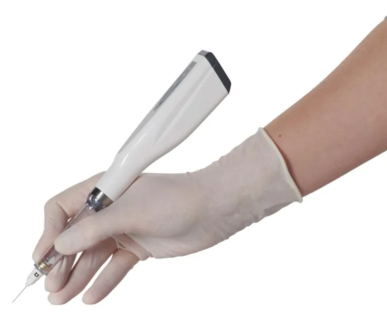 A hand in a white latex glove holds a white medical injection pen with a black tip and visible needle, poised for use. The sterile instrument and gloved hand suggest a clinical procedure, emphasizing safety and precision in healthcare settings.